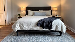 Une chambre avec un grand lit, deux tables de chevet et deux lampes.