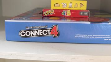 Une boîte de jeu Connect 4 avec des jeux de cartes UNO et UNO Kids placés sur le dessus.