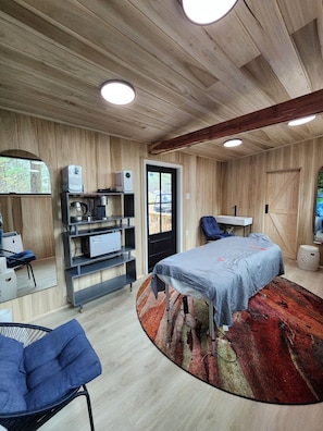 A modern bedroom with a bed, a desk, a chair, and a built-in shelf unit. - Spa King Cabin: Private Sauna & Soaking Tub (South Pittsburg)