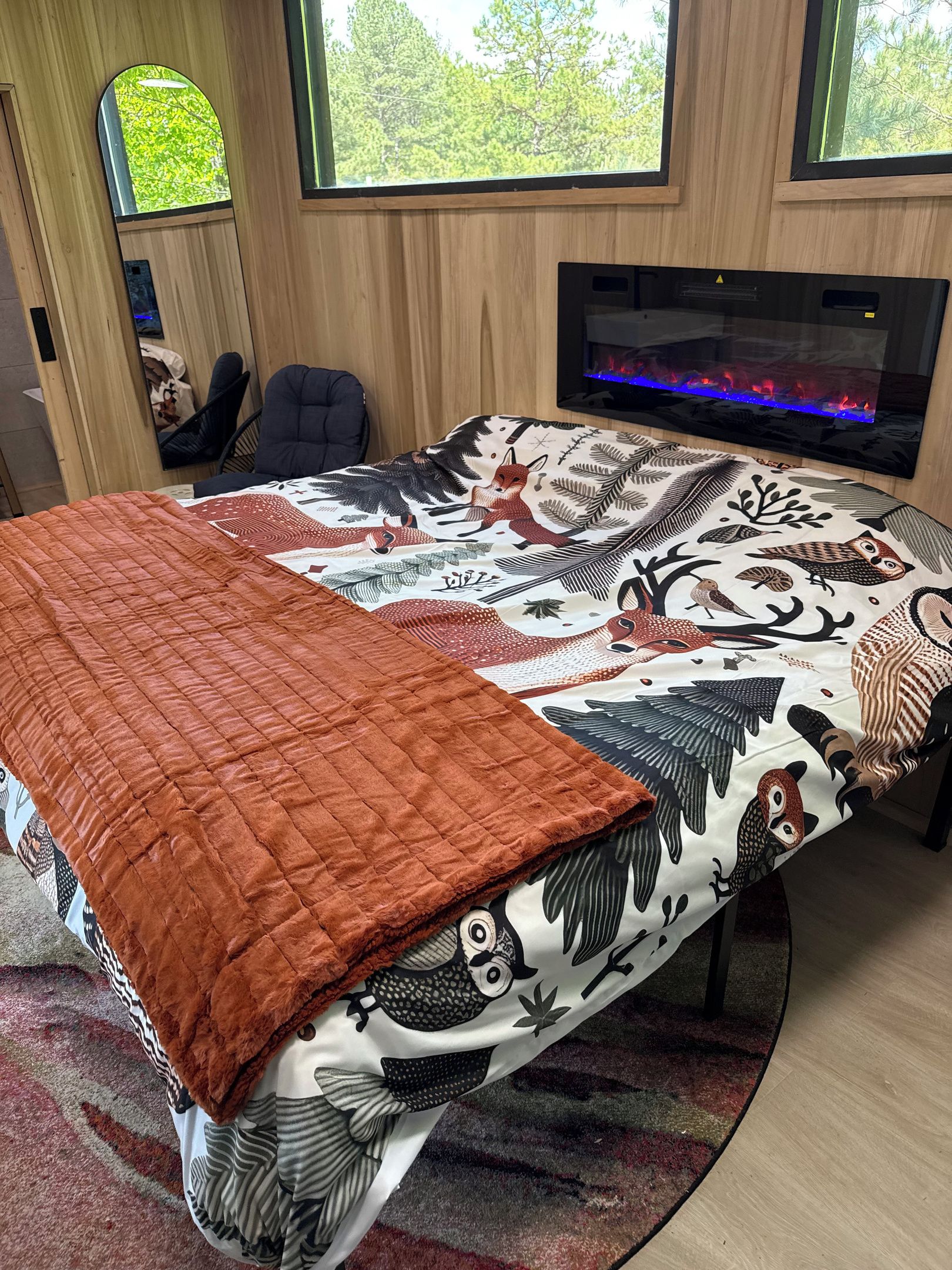 Un dormitorio con cama, chimenea y ventanas.