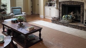 A spacious living room with a fireplace, a large mirror, and a bookshelf. - Spacious 4 Bed 3 Bath Auburn Game Day Home (Auburn)