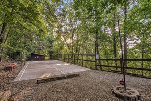A forested area with a paved path, benches, a small shelter, and a fence. - Lookout Point - Firepit, Pickle Ball, Balcony, Pet (Sevierville)