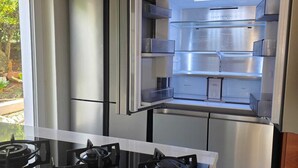 Een moderne keuken met een ingebouwde gasoven en een roestvrijstalen koelkast.