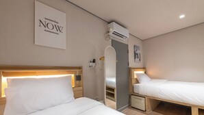 A hotel room with two beds, a mirror, an air conditioning unit, and a poster on the wall. - Hi Seodaemun (Seoul)