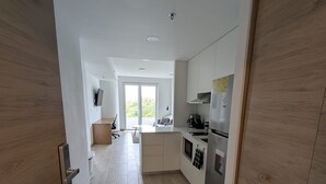 Eine moderne Küche mit Holzausstattung, einem eingebauten Backofen und einem großen Fenster.