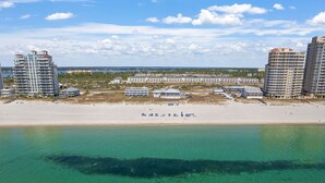 A beachfront hotel with multiple high-rise buildings, a sandy beach, and a clear view of the ocean. - Turner's Choice @ Lost Key Golf & Beach Club | Dog Friendly (Pensacola)
