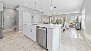 A spacious kitchen with a large island, stainless steel appliances, and pendant lighting. - Turner's Choice @ Lost Key Golf & Beach Club | Dog Friendly (Pensacola)