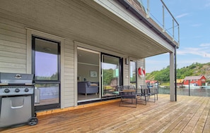 A modern house with a deck, a barbecue grill, and a view of boats on the water. - 5 bedroom gorgeous home in Bremnes (Bremnes)