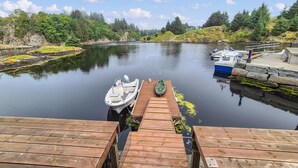 A wooden dock extending into calm water with boats moored at the end. - 5 bedroom gorgeous home in Bremnes (Bremnes)