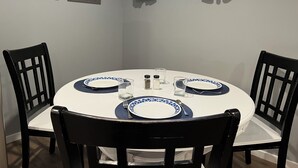 A round dining table with four chairs, two framed pictures on the wall, and a window with curtains. - Your private suite awaits.Half a block from Gryro park. Quite safe area! (Trail)