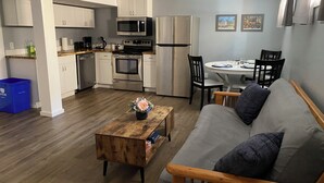 A compact living space with a kitchenette, a dining area, and a seating area with a sofa and a coffee table. - Your private suite awaits.Half a block from Gryro park. Quite safe area! (Trail)
