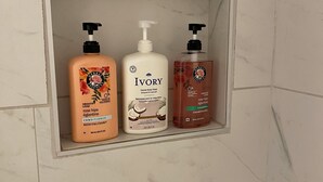 A bathroom shelf with three toiletry bottles. - Your private suite awaits.Half a block from Gryro park. Quite safe area! (Trail)