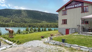 A building named 'LEDIGE ROM' with a view of a lake and mountains in the background. - Beautiful home in Nordberg with sauna (Nordberg)