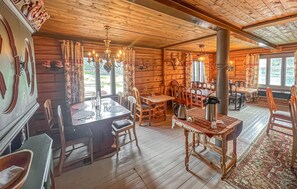 Eine rustikale Holzhütte mit Essbereich, mehreren Tischen und Stühlen.