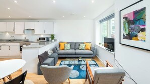 A modern living space with a kitchen, dining area, and seating area. - Shoreditch | 3 King Beds | Fast Wi-Fi | Balcony (London)