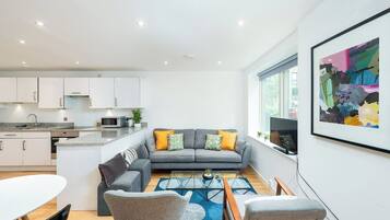 A modern living space with a kitchen, dining area, and seating area.