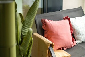 A bed with a black headboard, a pink pillow, and a white pillow with a floral pattern.