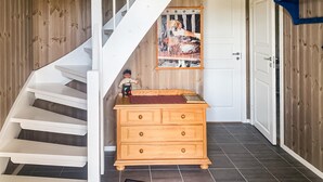 A staircase leading to a room with a wooden dresser and a framed picture on the wall.