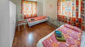 A room with two beds, a chair, and a radiator. - Awesome home in Kongshus with sauna (Kongshus)