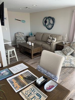 Sala de estar com sofá, mesa de centro e um objeto decorativo na parede.