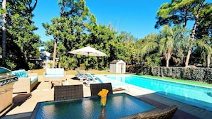 Une piscine avec des chaises longues et un barbecue.