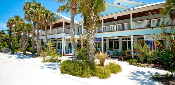 A two-story building with a covered porch and a flag.