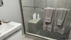 Une salle de bain moderne équipée d’une baignoire, de toilettes et d’un espace douche.