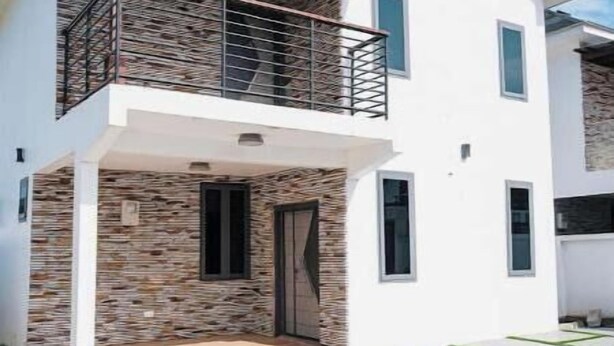 A two-story modern house with a balcony, a stone facade, and a tiled patio. - Solace Villa (Tema)