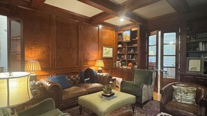 A traditional living room with wooden paneling, leather furniture, and a patterned carpet. -  Sophisticated Stay in heart of Five Points-Walk to the action, Relax in luxury. (Athens)