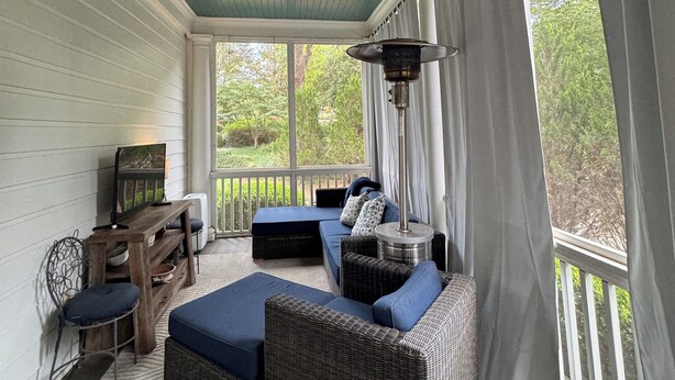 A covered porch with a ceiling fan, a seating area with blue cushions, wicker furniture, and a view of greenery outside. -  Sophisticated Stay in heart of Five Points-Walk to the action, Relax in luxury. (Athens)