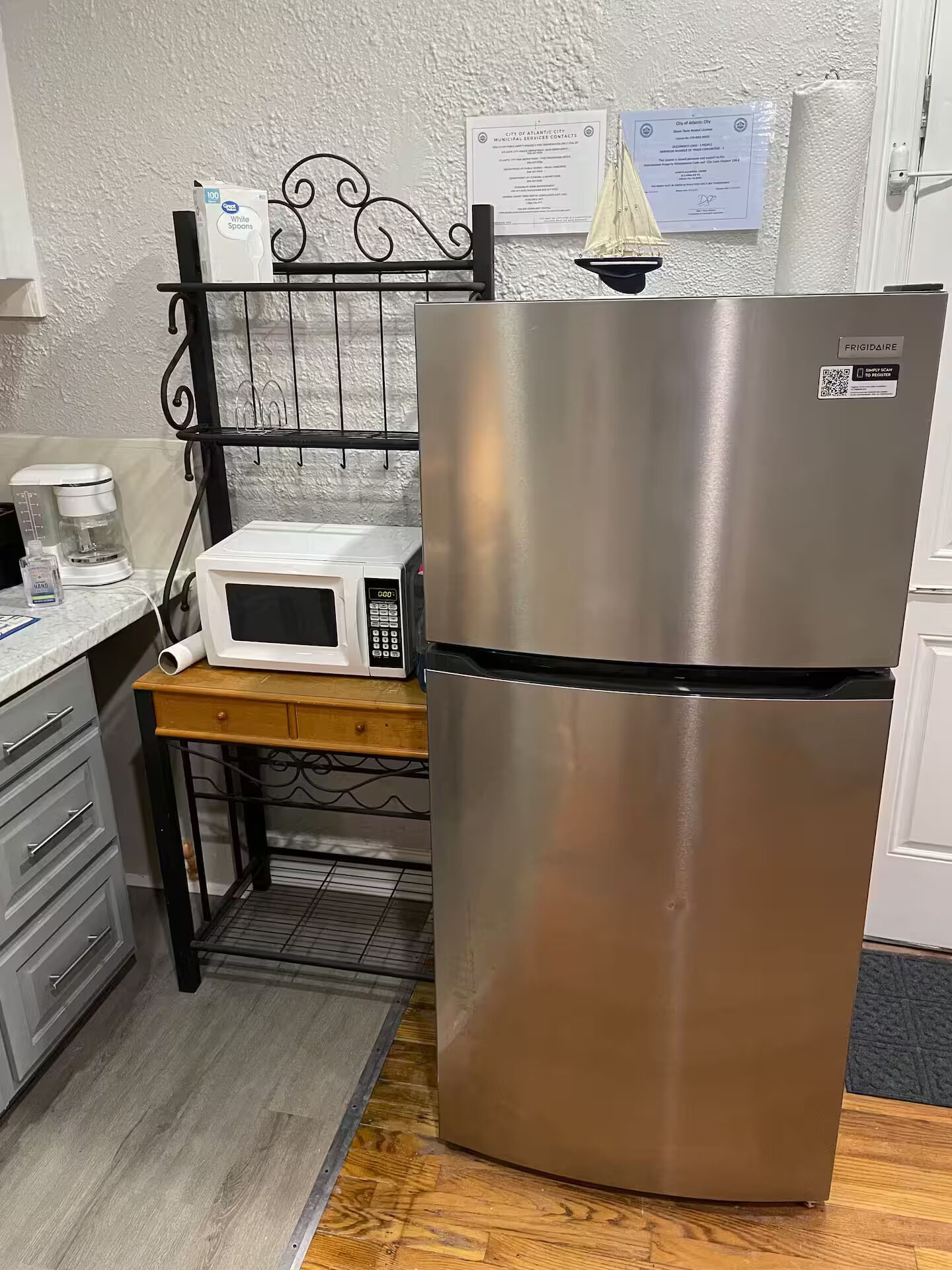 A kitchen with a stainless steel refrigerator, a microwave, and a coffee maker on the counter.