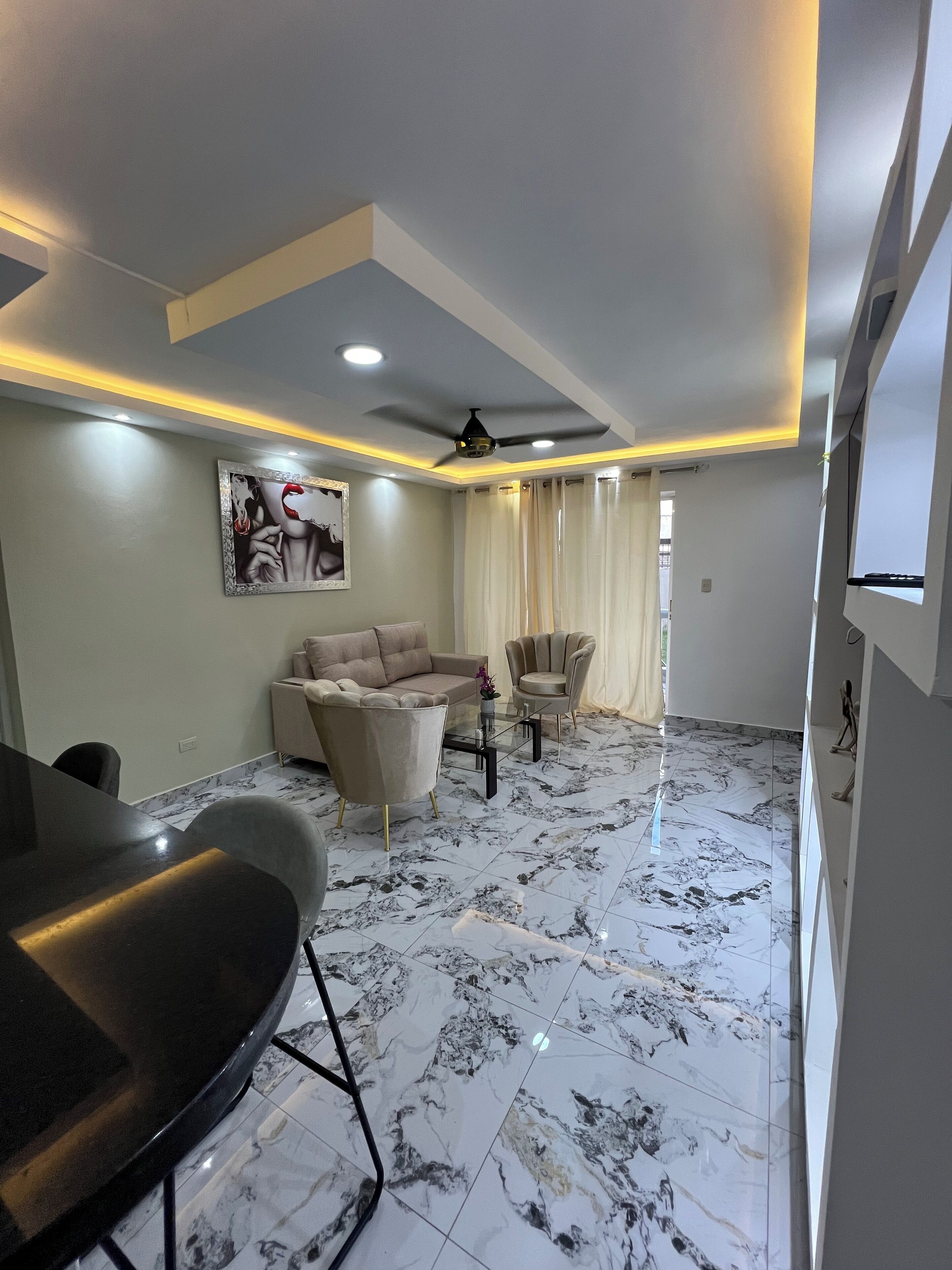 A modern living room with a marble floor, a sofa, a coffee table, and a dining table.