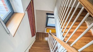 A wooden staircase with white railings and a red curtain. - Hinterhov Koje by Interhome (Beeskow)