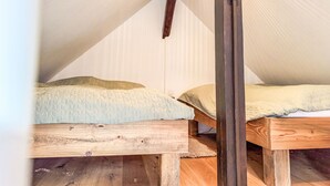A small attic bedroom with two wooden beds, a slanted ceiling, and a hanging light fixture. - Hinterhov Koje by Interhome (Beeskow)