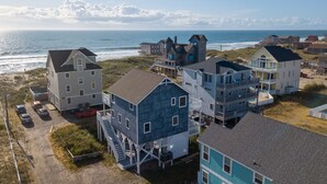 A coastal residential area with houses near the beach, featuring a mix of modern and traditional architecture.
