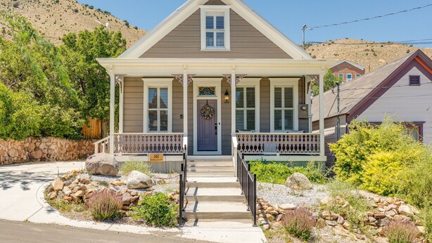 A two-story house with a front porch, a stone wall, and a mountain backdrop. - Historic Gem in Virginia City (Virginia City)
