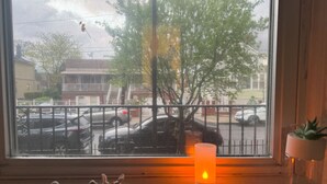 A window with a view of parked cars and buildings outside.