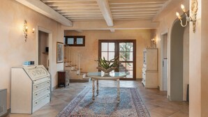 A spacious kitchen with a central island, a built-in stove, and a large window providing natural light. - Podere Delle Vigne, in the Vineyards of Maremma (Grosseto)