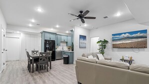 Una cocina moderna con armarios color turquesa, un refrigerador negro y un ventilador de techo.