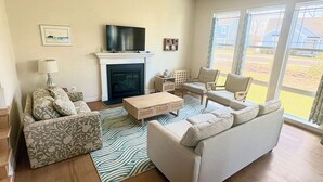 A living room with a fireplace, a television, and two sofas. - Delaware getaway near Bethany Beach (Ocean View)