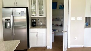 A modern kitchen with stainless steel appliances, white cabinetry, and a coffee maker on the counter. - Delaware getaway near Bethany Beach (Ocean View)