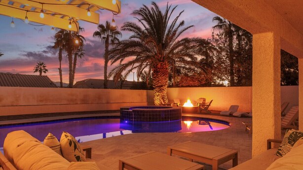 A pool area with lounge chairs, a hot tub, and a sunset view. - Sun and Shade Oasis  by J and Amy BL 991449 (Mesquite)