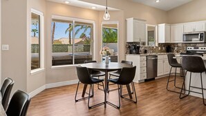 A modern kitchen with white cabinets, a granite countertop, and a built-in oven. - Sun and Shade Oasis  by J and Amy BL 991449 (Mesquite)