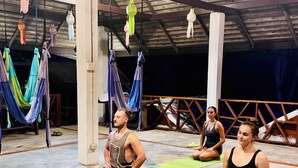 A spacious indoor area with multiple yoga mats and hammocks. - The Nest Pai Love Resort (Pai)