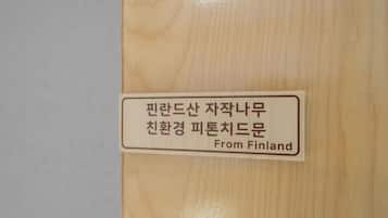 Una puerta de madera con una etiqueta que dice "Finlandia" y texto en coreano.