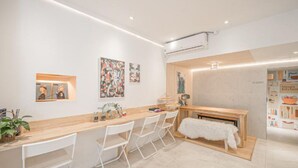 Una cocina moderna con sillas blancas, un mostrador de madera y una alfombra blanca y mullida.