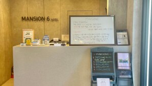 A reception desk at the MANSION 6 HOTEL with a whiteboard displaying a menu and a blackboard with a list of items. - POHANG MANSION 6 HOTEL (Pohang)