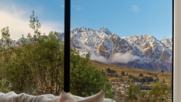 A mountain landscape with snow-capped peaks and a valley below.