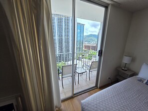 Ein Hotelzimmer mit Balkon, einem Bett, einem Stuhl und einem Tisch.