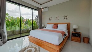 Ein modernes Schlafzimmer mit einem großen Bett, einem Nachttisch und Blick auf Grünfläche.